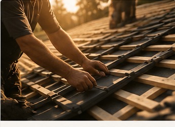 Dachdecker verlegt Lattung auf einem Steildach